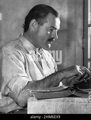 The american writer Ernest Hemingway, author of For Whom the Bell Tolls and The Old Man and the Sea, working on his book For Whom the Bell Tolls at the Sun Valley Lodge, Idaho, in December 1939, aged 40. Stock Photo