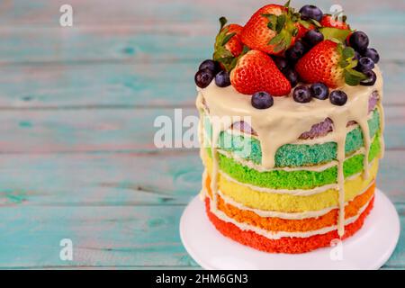 Festive multi layered cake with fresh strawberry. Birthday rainbow cake. Stock Photo