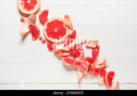 Tasty grapefruit pieces on light wooden background Stock Photo