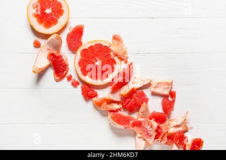 Tasty grapefruit pieces on light wooden background Stock Photo