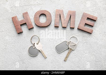 Word HOME and keys with stylish keychains on light background Stock Photo