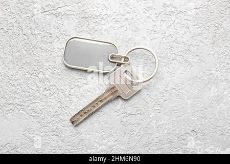 Key with stylish metallic keychain on light background Stock Photo