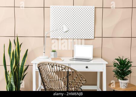 Modern workspace and office supplies with peg board on wall Stock Photo