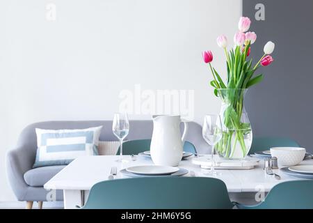 Dining table with stylish setting and vase with tulips Stock Photo