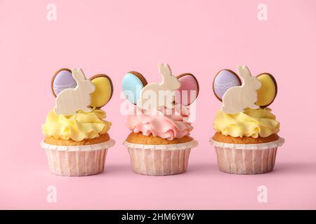 Tasty Easter cupcakes on pink background Stock Photo