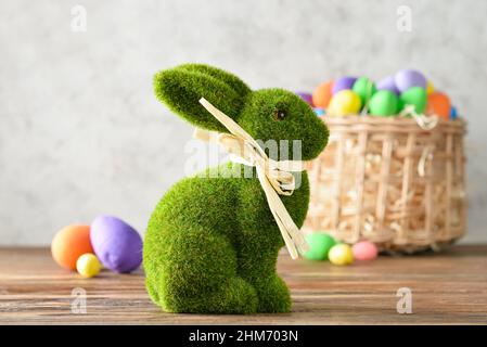 Easter bunny and wicker basket with painted eggs on grunge background Stock Photo