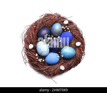 Nest with beautiful Easter eggs and gypsophila flowers on white ...