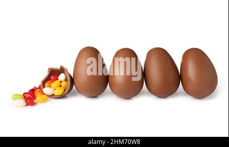Delicious chocolate Easter eggs and different candies on white background Stock Photo