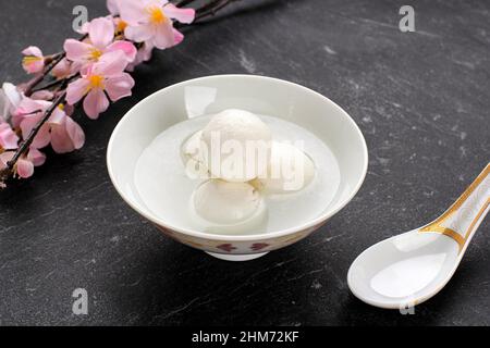 Tang Yuan Wedang Ronde, Chinese Glutinous Rice Dumpling Balls with Sugar Ginger Syrup on Red Chinese on Red  Background for Winter Solstice New Year o Stock Photo