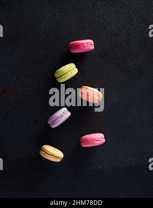 Colorful assorted macarons or macaroons on black background. Stock Photo
