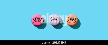 Colorful macarons with happy, neutral and sad faces. Customer rating and evaluation concept. Stock Photo