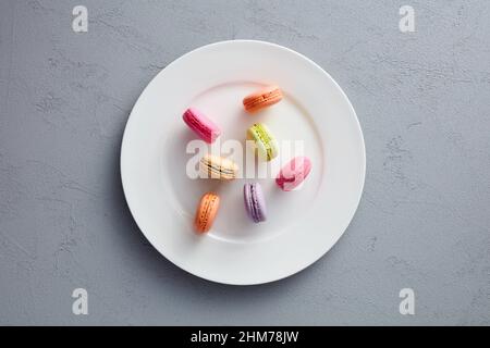 Colorful assorted macarons or macaroons on white dish. Stock Photo