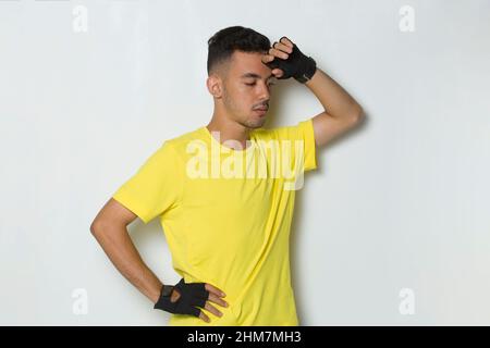 Young handsome sport man feeling tired after workout on white background Stock Photo