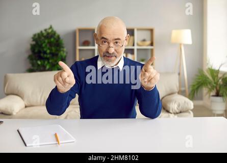 Confident senior businessman looking at camera has business talk with clients or partners online. Stock Photo