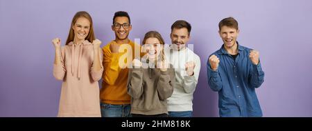 Young people expressing their excitement and delight by shouting Yes and clenching fists. Stock Photo