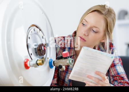 female worker on gas boiler Stock Photo