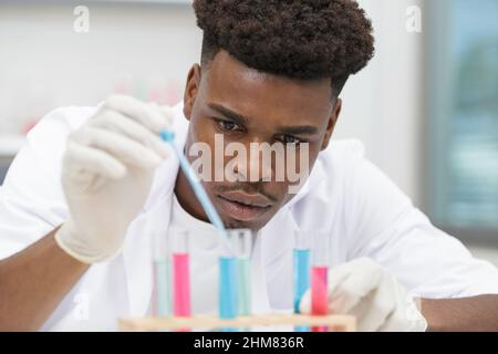 young man scientist using auto-pipette Stock Photo