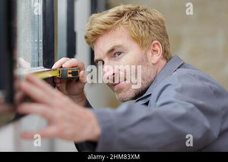 a worker metering a window Stock Photo