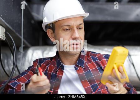 electrician reading result on multimeter Stock Photo