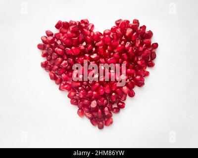 Heart from pomegranate seeds isolated on white background. Heart shape. High quality photo Stock Photo