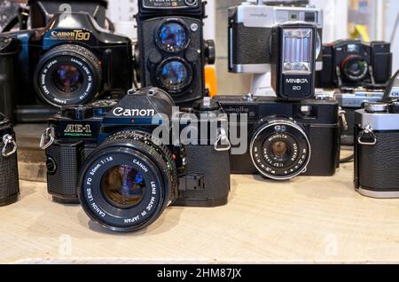 BUDAPEST - JAN 20: Old vintage photo cameras Canon, Minolta on a shelf of Commission shop at flea market in Budapest, January 20. 2022 in Hungary Stock Photo