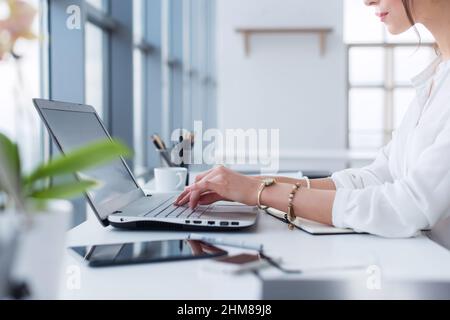 Side view portrait of woman working in home-office as teleworker, typing and surfing internet, having work day Stock Photo