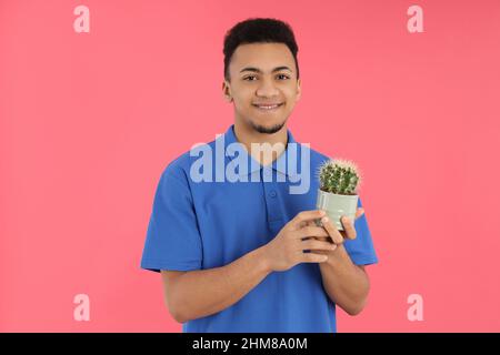Young man with cactus on pink background Stock Photo