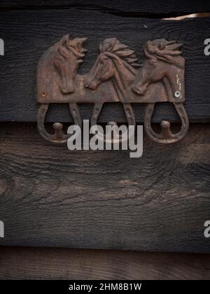 Vertical view of clothe hanger in the shape of three horses with horse shoe to hang the clothes from. Stock Photo