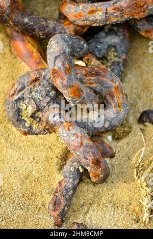Rusty Chain on the beach still connected Stock Photo