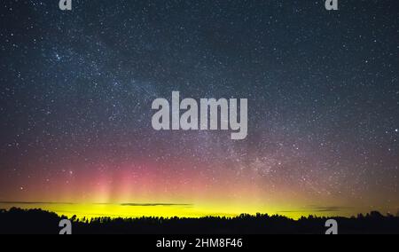 Milky way and Northern lights - Aurora borealis over the forest Stock Photo