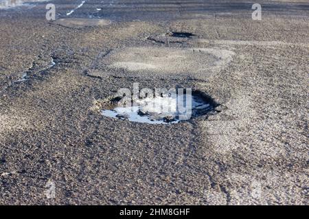 Pit on the asphalt. Broken road surface Stock Photo