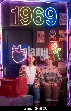 Kyiv, Ukraine - December 16, 2021: Millennial friends have fun together in a disco club with a retro style. Nostalgia for the '90s in neon style Stock Photo