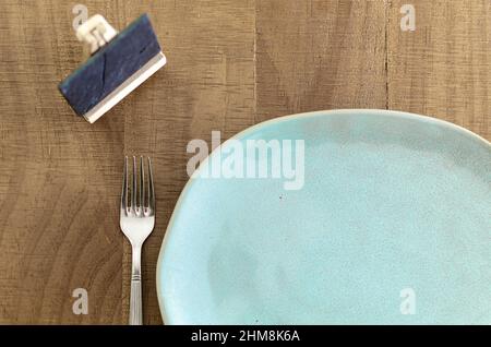 Empty plate with fork on a wooden table. Top view. Stock Photo