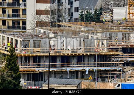 Construction workers install formwork and iron rebars or reinforcing bars for reinforced concrete partitions at residential building construction site Stock Photo