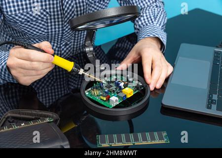 Cropped image of male hands working with motherboard isolated over blue background Stock Photo