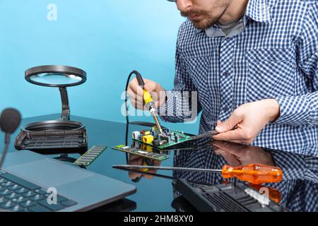 Cropped image of male hands working with motherboard isolated over blue background Stock Photo