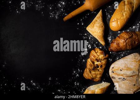 freshly baked pastry goods on black background with copy space. top view Stock Photo