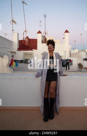 Trendy black female resting on terrace in Cadiz, Spain Stock Photo