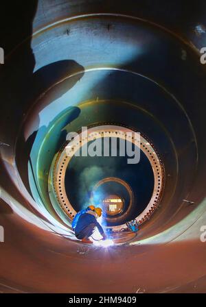 LIANYUNGANG, CHINA - FEBRUARY 8, 2022 - A worker produces a wind tower at a workshop of Chongshan Wind Equipment Company in Lianyungang Economic and T Stock Photo