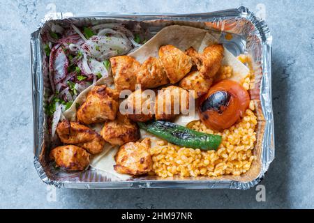 Take Away Turkish Chicken Kebab in Aluminum Foil Food Container. Take Out Dish. Ready to Eat and Serve. Stock Photo