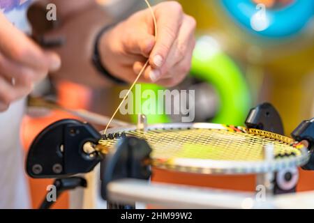 manual stringing of a badminton racket in service Stock Photo