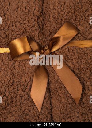 Full frame macro shot of brown fluffy blanket wrapped with brown silky ribbon Stock Photo