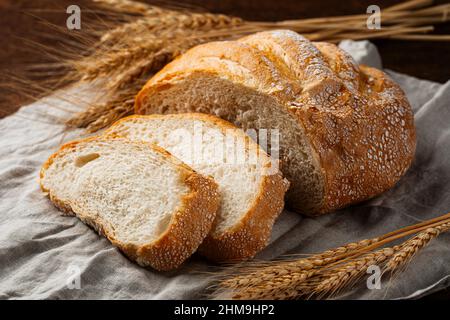 Baked sliced loaf of creamy bread on napkin Stock Photo