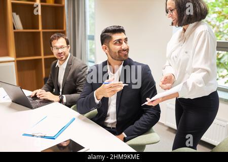 Older business woman as boss and young business man as trainee work together in the office Stock Photo