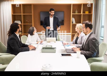 Young business man as a speaker or consultant with a team giving a presentation in the consulting workshop Stock Photo