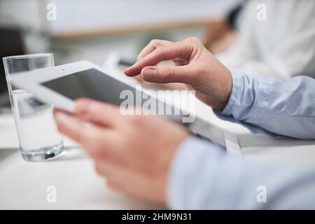 Hands of business man typing on touch screen of tablet computer in office Stock Photo