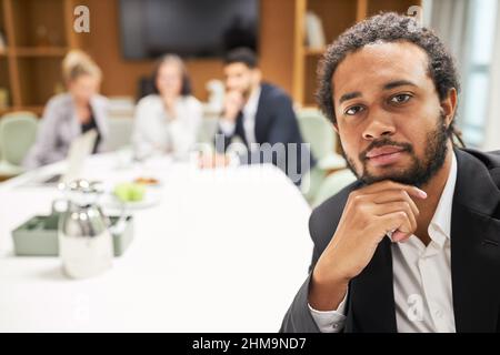 African business man as a thoughtful start-up founder with business team in the background Stock Photo