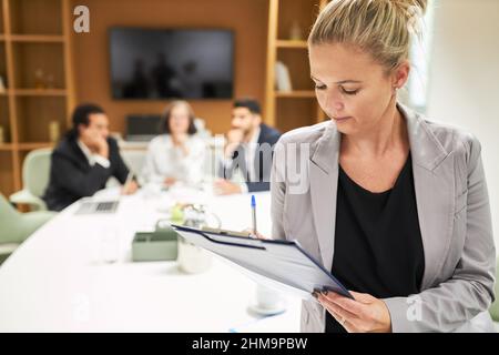 Business woman with checklist on clipboard checking the minutes after the business meeting Stock Photo