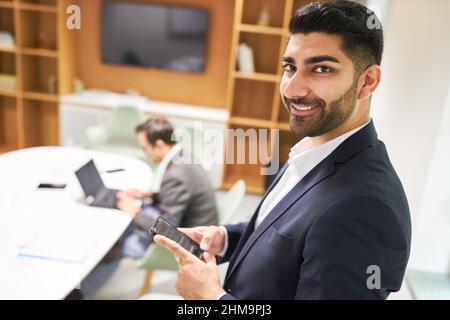 Business man as a successful start-up founder using smartphone in the conference room in the office Stock Photo
