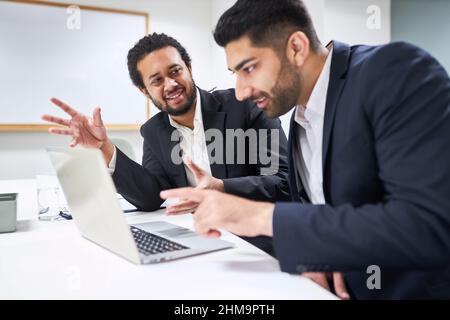 Two young business people work together as creative software developers on the laptop PC Stock Photo